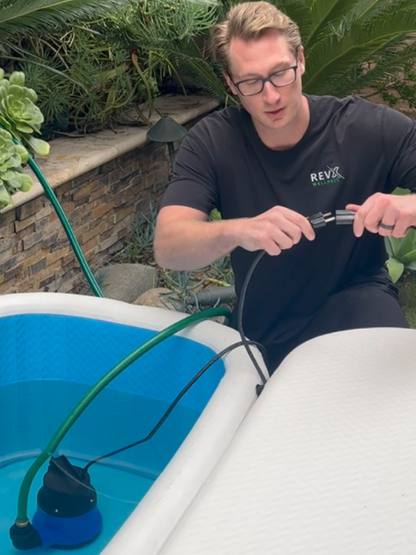 Man draining a cold plunge with the RevX drain pump and hose