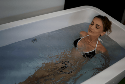 Woman immersed in the RevX Acrylic X Tub cold plunge